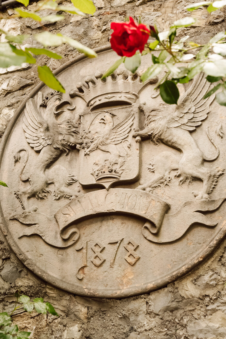 Wappenstein am Schloss Wiespach mit der Jahreszahl 1878 und einer Rose.