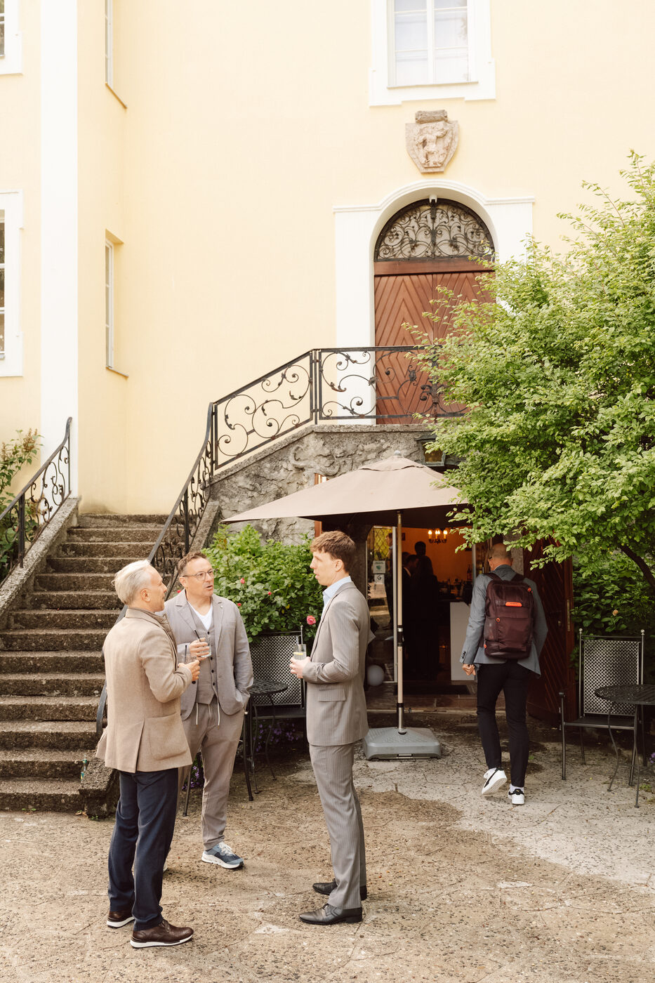 Drei Mitglieder im Gespräch im Innenhof vor dem Eingang.